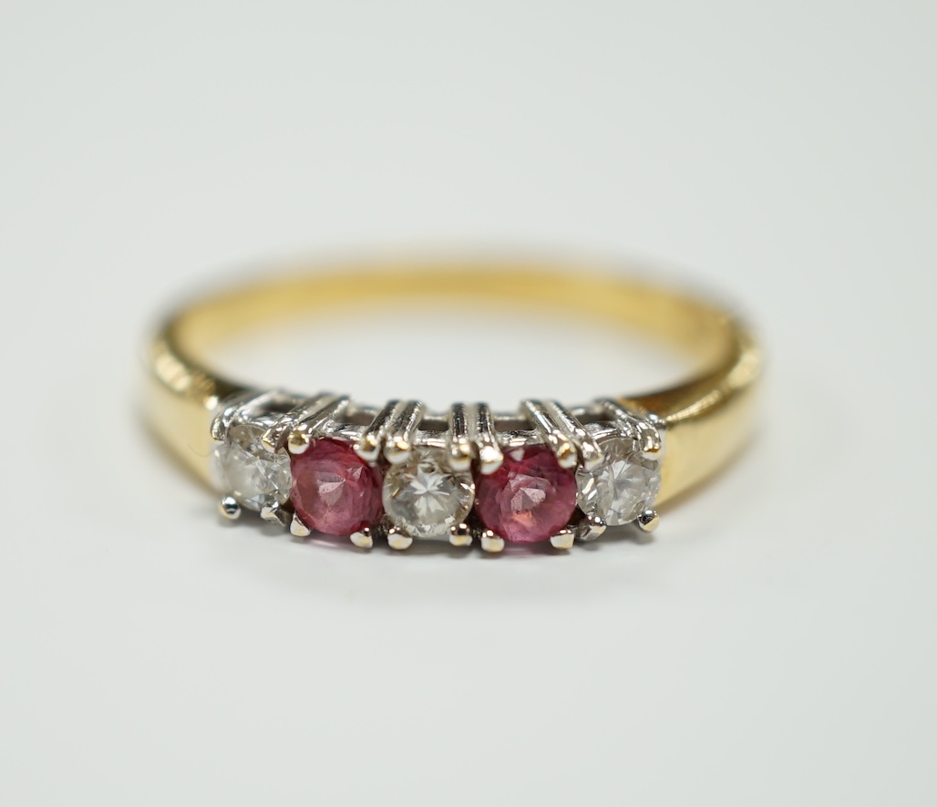 An 18ct gold, two stone pink sapphire? and three stone diamond set half hoop ring, size O, gross weight 3.3 grams.